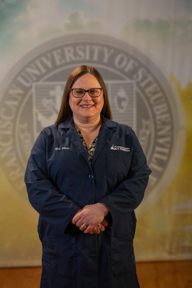 Tanya Dillion standing in front of a university seal.